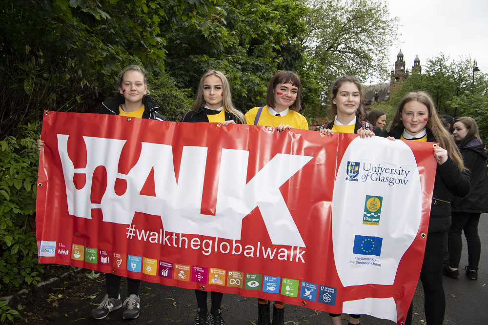 Students participating in the Global Walk 2019 hold up the WTGW banner.